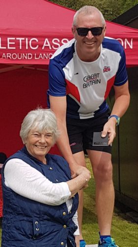 Mark Crompton receives his mgold medal from Margaret Crompton 